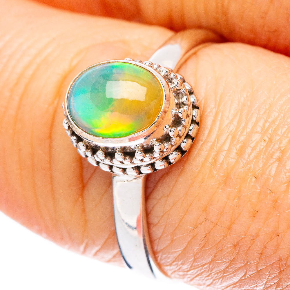 Sterling silver opal ring with oval green-gold stone and beaded halo settings