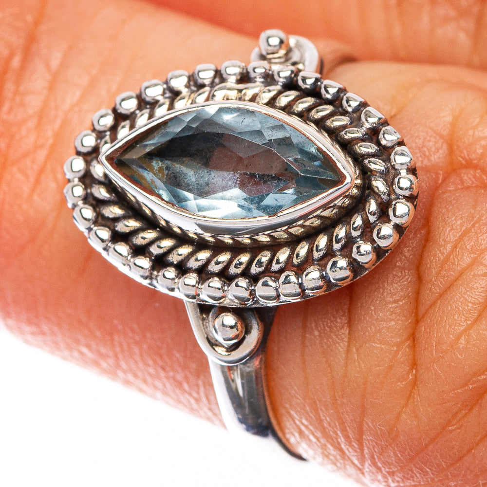 Sterling silver ring with oval blue topaz and beaded halo detail