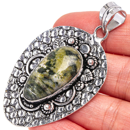 German silver pendant with oval green-gray stone, ornate bezel and bail