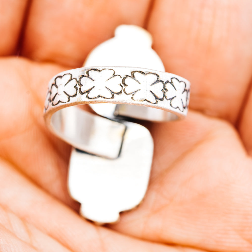 Sterling silver band with leaf-and-flower engraving and smooth inner face