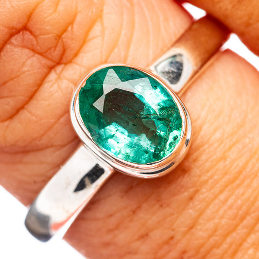 Bezel-set oval emerald-green gemstone sterling silver ring, close-up
