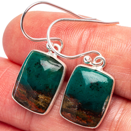 Opalized wood earrings on silver hooks, teal squares with warm red-gold edges close-up