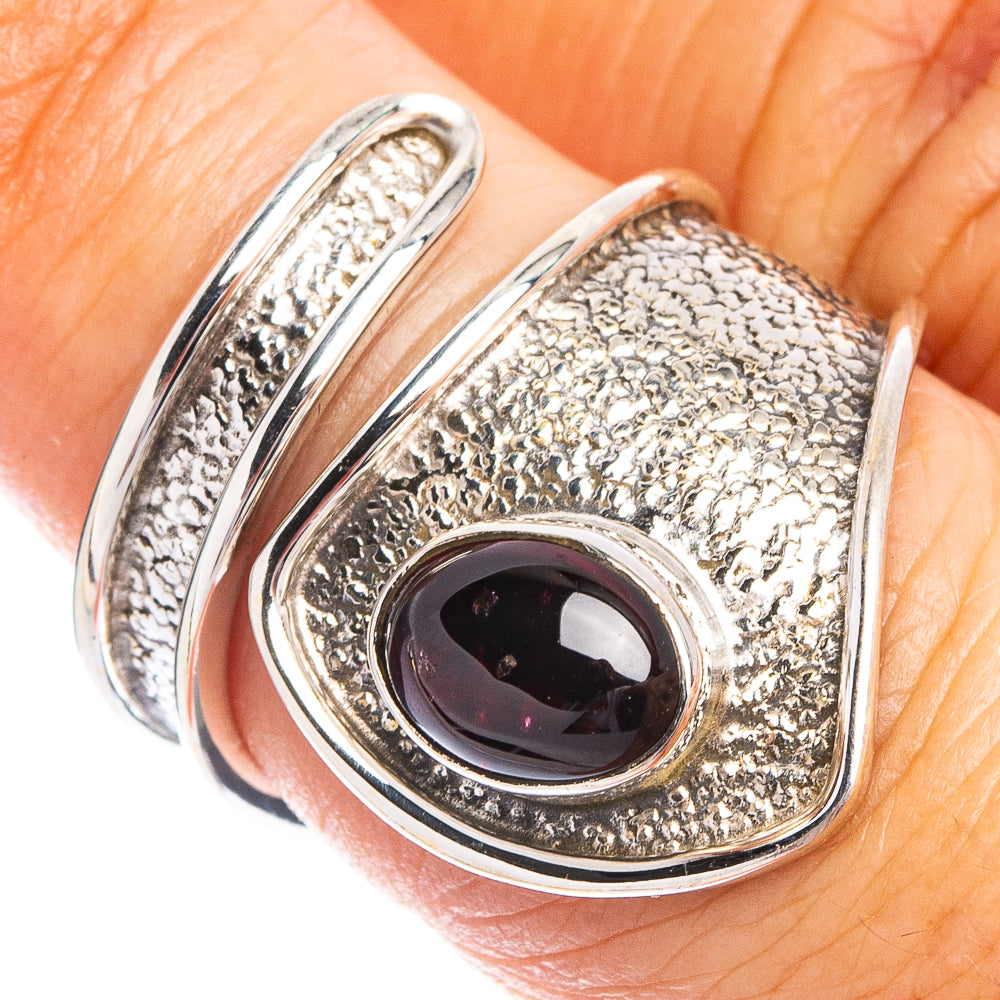 Sterling silver ring with oval garnet gemstone and textured teardrop bezel
