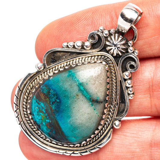 Silver pendant with oval chrysocolla stone and ornate filigree bezel