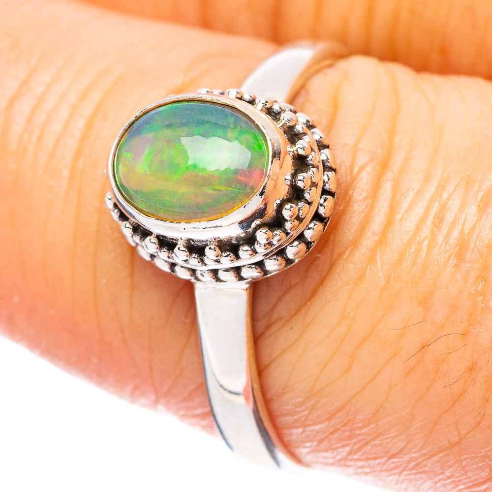 Sterling silver opal ring with oval green stone and ornate halo bezel