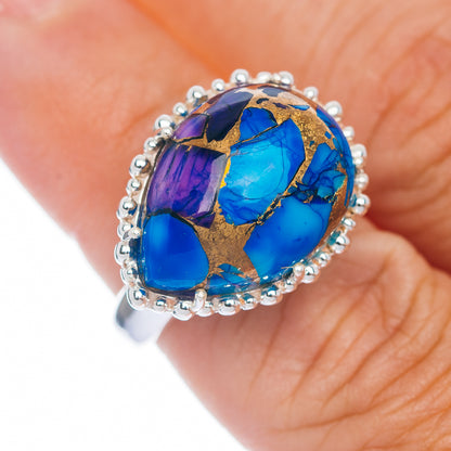Oval gemstone ring with blue and purple mosaic, gold accents, and silver halo