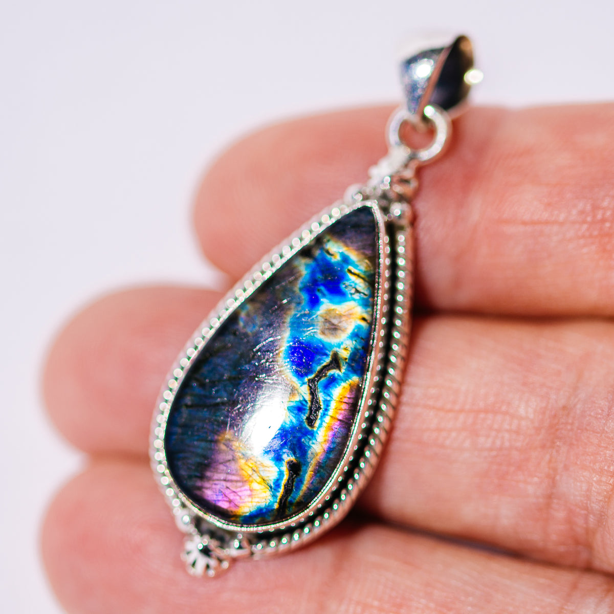 Spectrolite pendant in a sterling silver beaded setting, with a colorful teardrop gemstone