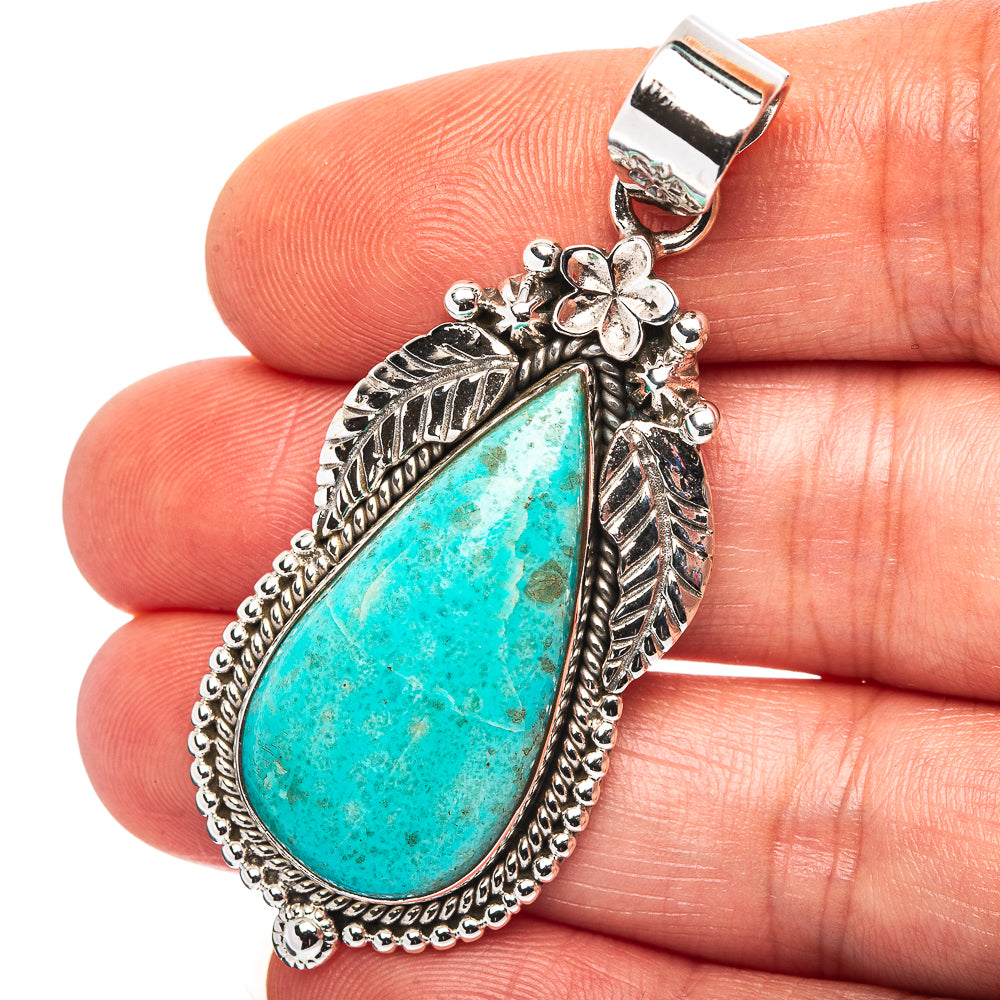 Turquoise teardrop pendant with ornate sterling silver leaf and flower design bail