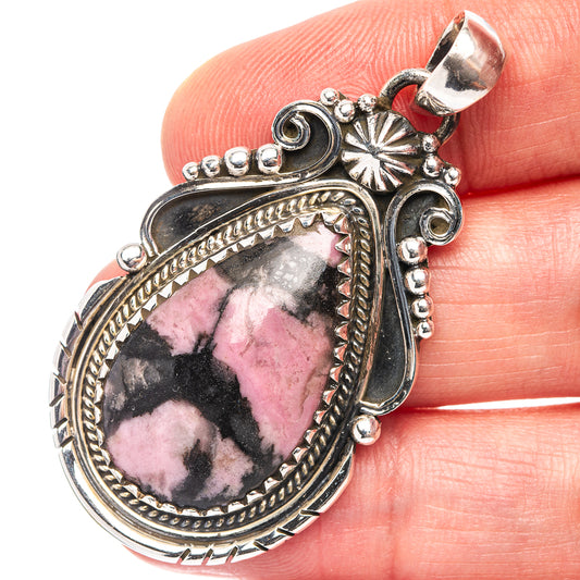 Sterling silver rhodonite pendant with faceted pink teardrop stone and loop bail detail.