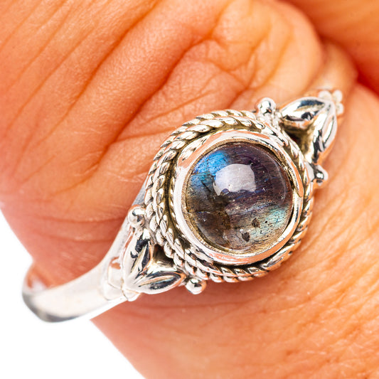 Sterling silver labradorite ring on finger, round oval blue-sheen stone and rope border