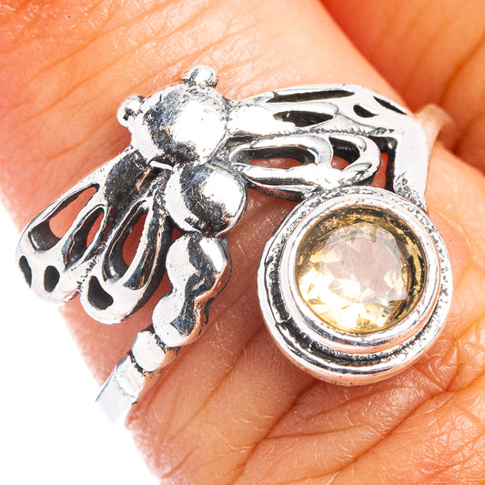Sterling silver dragonfly ring on finger, round citrine-like bezel setting