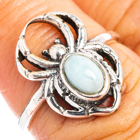Sterling silver spider dainty ring, oval light-blue Larimar stone on finger