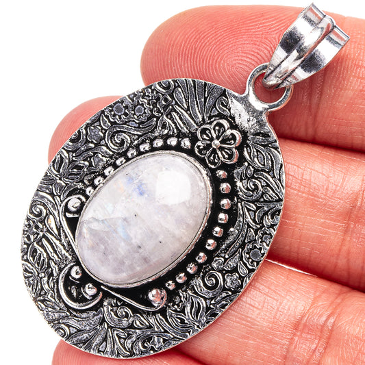 Rainbow moonstone pendant with oval cabochon in engraved silver-tone frame