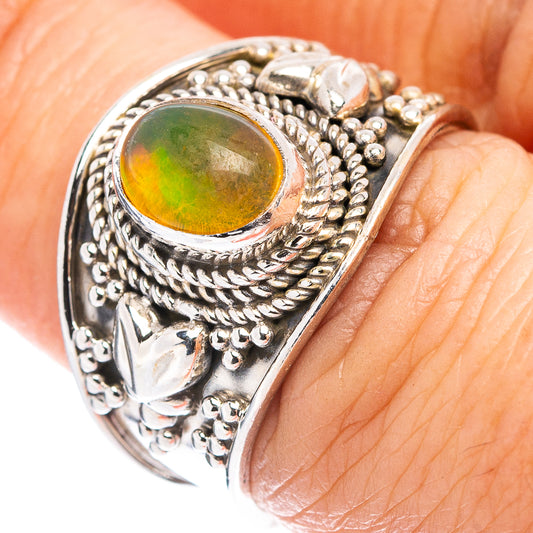 Sterling silver opal ring with oval green-orange Ethiopian opal center and ornate rope bezel
