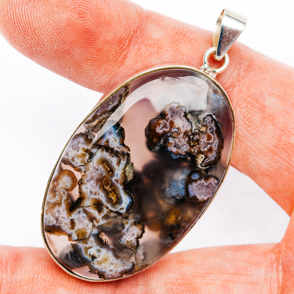 Oval sterling silver agate pendant with dark brown, white, and blue stone detail