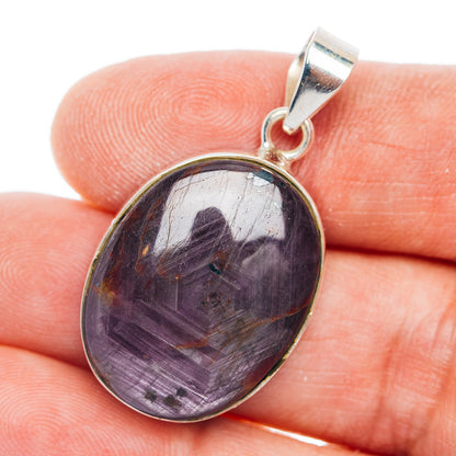 Sterling silver oval pendant with purple star ruby cabochon in raised bezel.