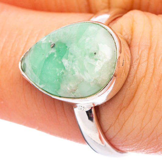 Sterling silver ring with oval green cabochon gemstone on finger