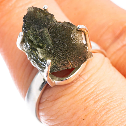 Sterling silver ring with rough dark green stone, prong top view on hand