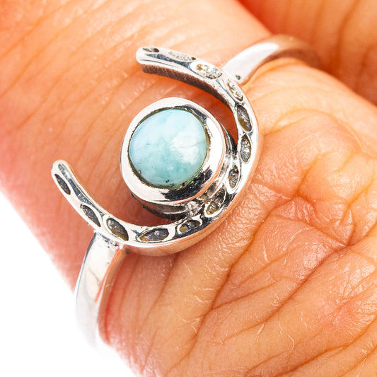 Sterling silver open horseshoe ring with turquoise Larimar oval cabochon on finger