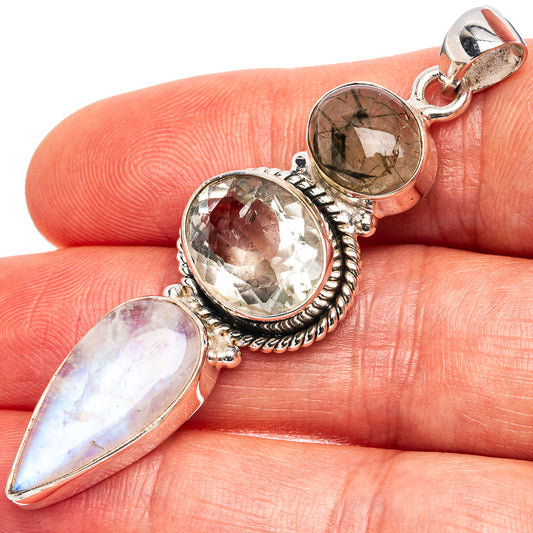 Sterling silver pendant with three faceted gemstones, including an oval and a round stone