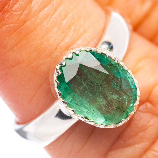 Faceted emerald ring with silver prong setting and round green gemstone, size 6