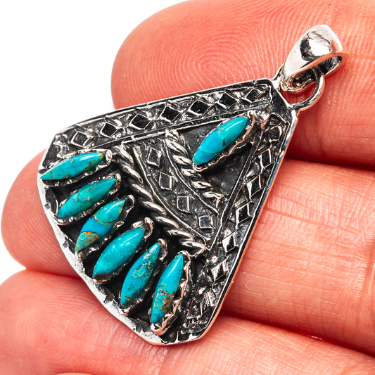 Sterling silver turquoise pendant with bezel-set oval stones and ornate etched design