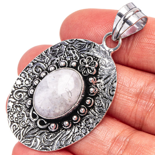 Moonstone pendant, oval cabochon set in ornate German-silver floral border with bail