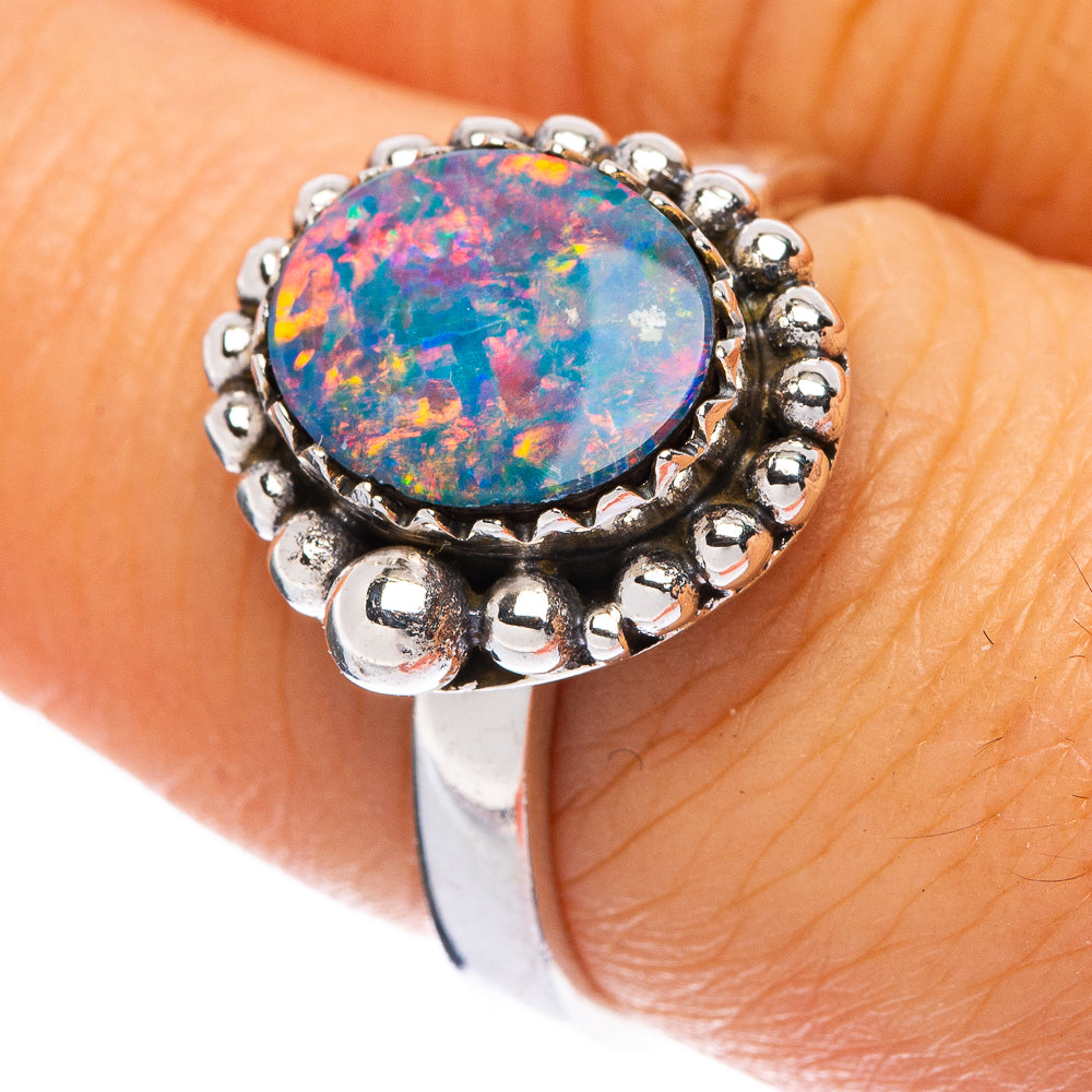 Synthetic opal gemstone ring with round blue-red mosaic center, silver bead band