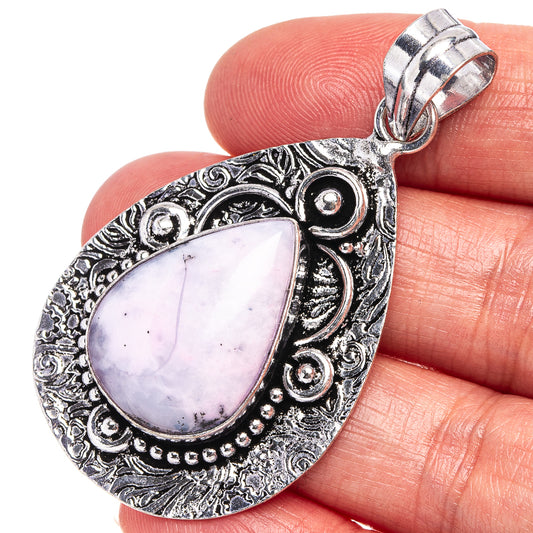 Dendritic opal pendant with teardrop lavender cabochon and ornate silver-toned filigree bail.