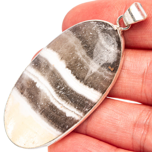Zebra calcite pendant in silver-plated teardrop bail, banded gray and cream stone