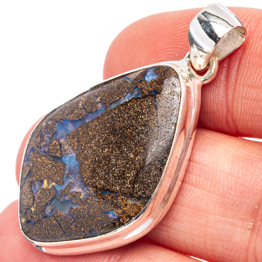 Sterling silver boulder opal pendant, bezel set with blue flecks on dark brown rock.