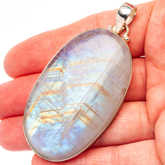 Oval rainbow moonstone pendant in sterling silver bezel with loop bail