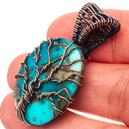Turquoise oval pendant with oxidized copper wire wrap and textured stone face