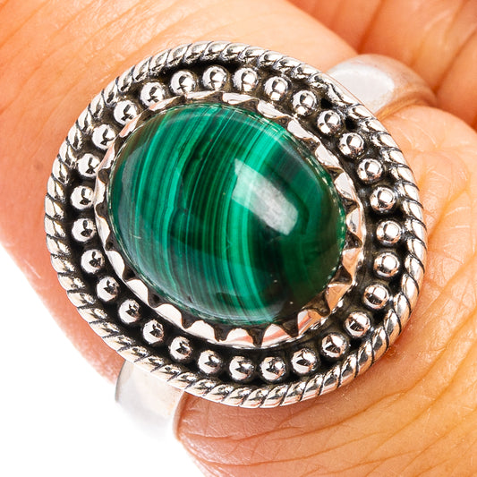 Sterling silver ring with oval green malachite cabochon and beaded halo setting