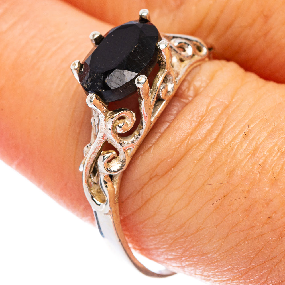 Black onyx dainty ring with ornate silver filigree, oval stone, on finger