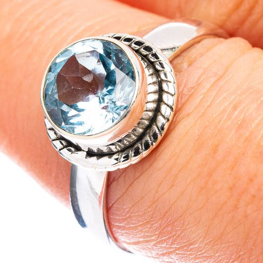 Sterling silver topaz ring with round blue faceted gemstone and engraved bezel detail