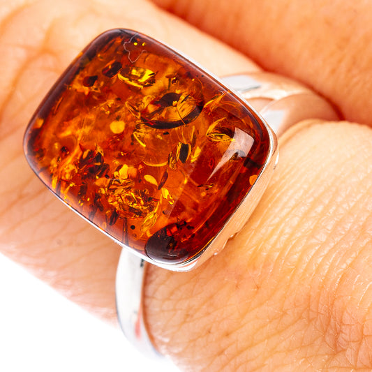 Close-up of oval amber cabochon on silver adjustable ring band