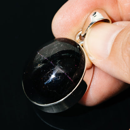 Round black star garnet pendant close-up with sterling silver bail and loop