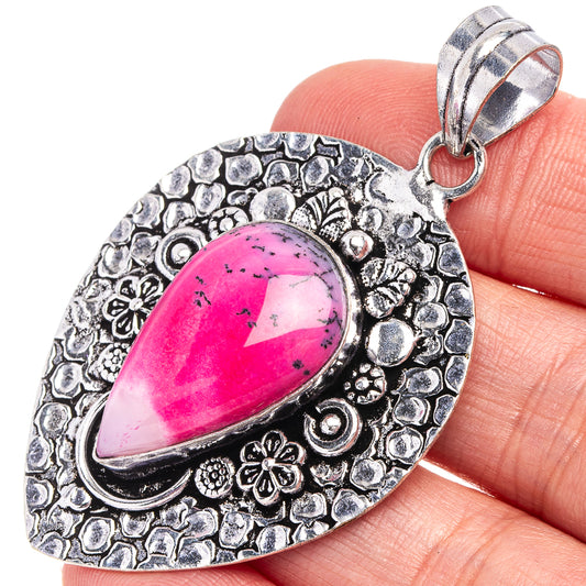 Silver-tone teardrop opal pendant with pink dendritic stone and engraved floral bezel