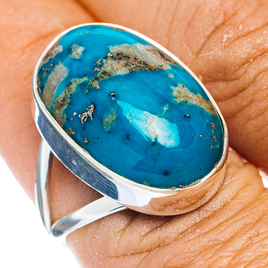 Sterling silver oval ring with bright turquoise cabochon gemstone on finger