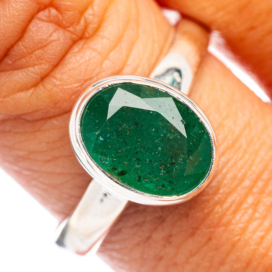 Sterling silver ring with round green emerald bezel, worn on a hand