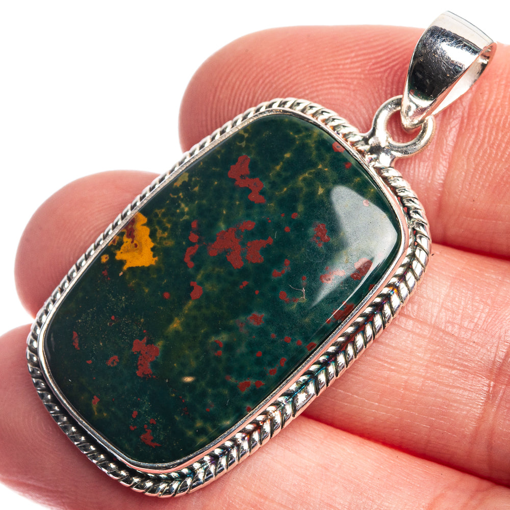 Oval bloodstone pendant with red speckles, bezel-set in sterling silver, round bail.