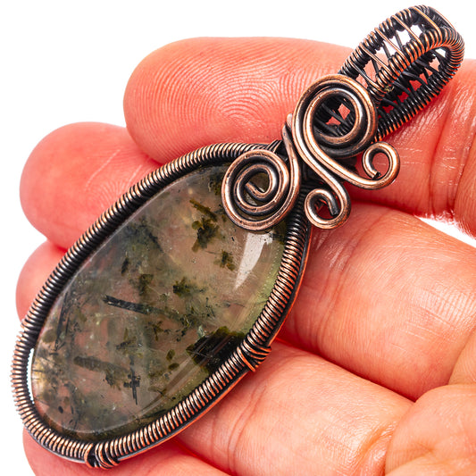 Oxidized copper wire wrap pendant close-up with prehnite cabochon and spiral coils