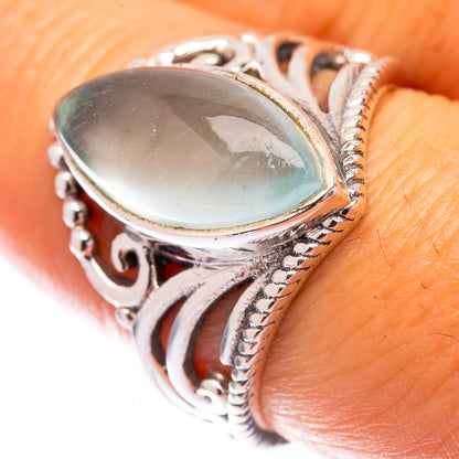 Sterling silver oval aquamarine ring with blue bezel and ornate side filigree
