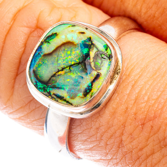 Oval opal sterling silver ring with iridescent green-blue stone set in bezel