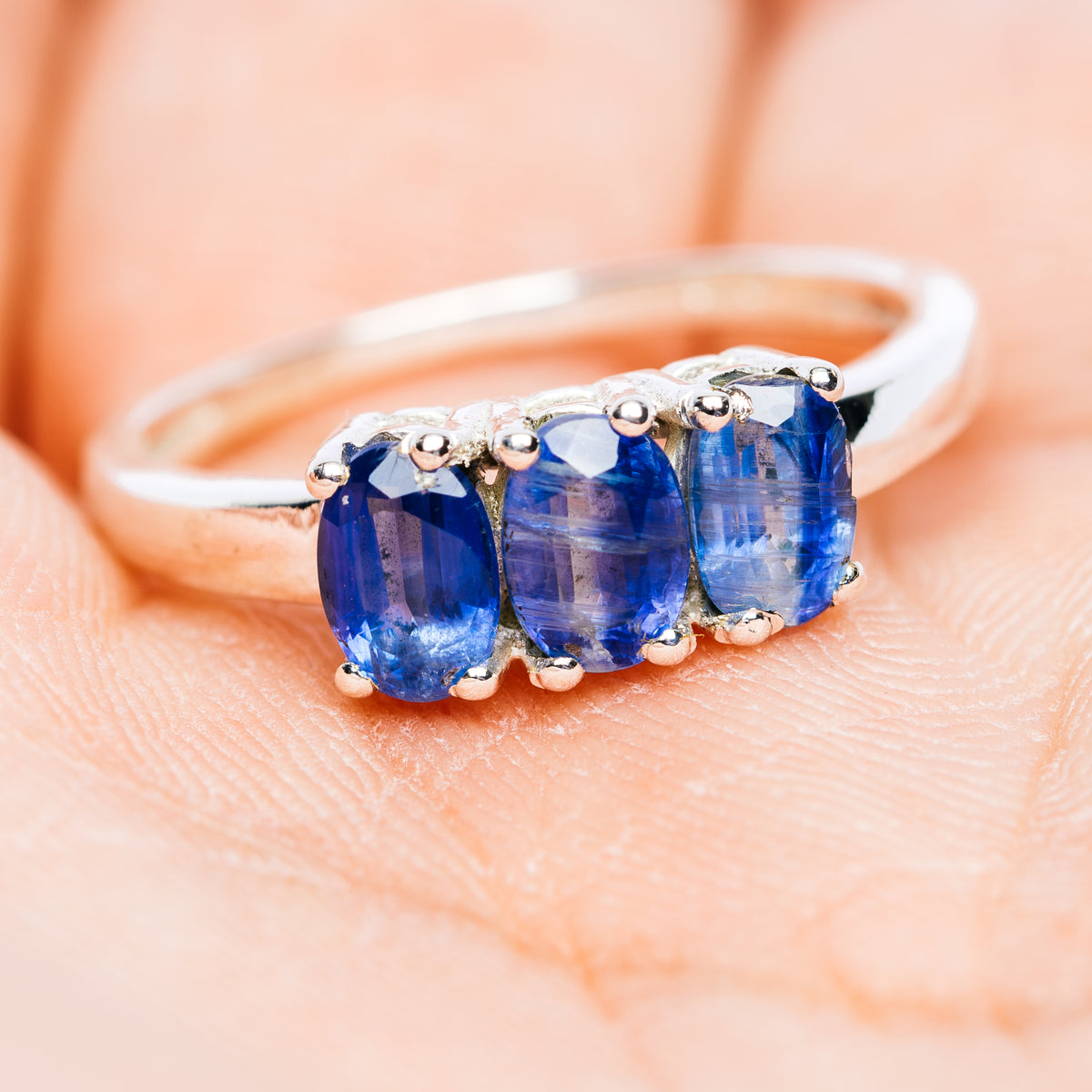 Sterling silver three-stone kyanite ring with three oval blue gemstones on band