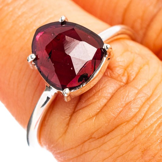 Faceted garnet ring with oval dark red stone in silver prong setting