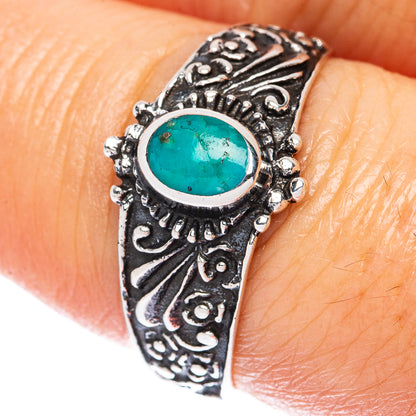 Ornate sterling silver ring with oval turquoise cabochon and engraved band