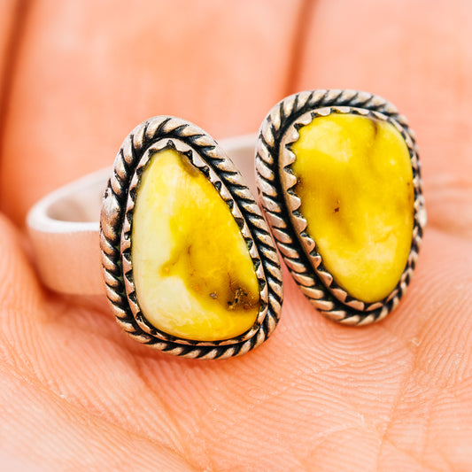 Sterling silver oval gemstone ring, yellow stone in rope bezel, front view on hand