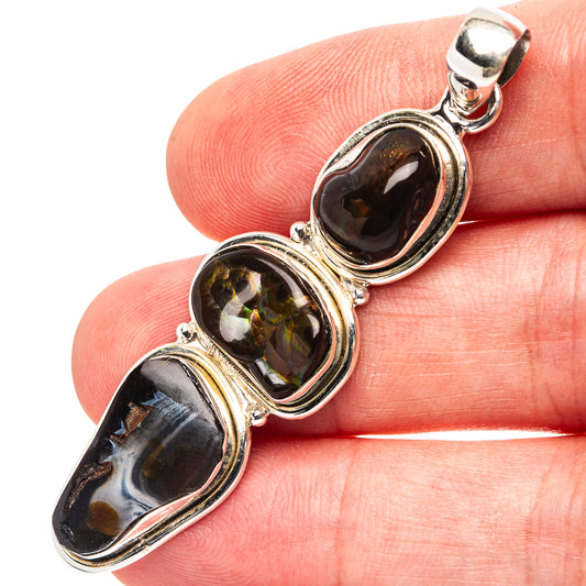Oval fire agate pendant with three bezel-set stones in .925 sterling silver, close-up on hand